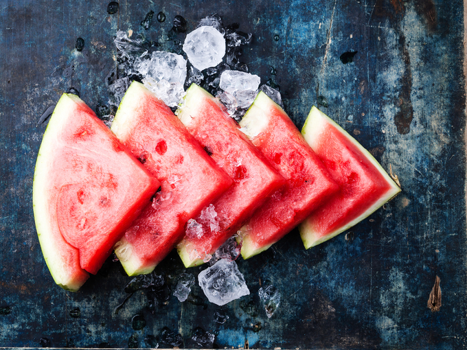 Watermelon slices and ice on blue background